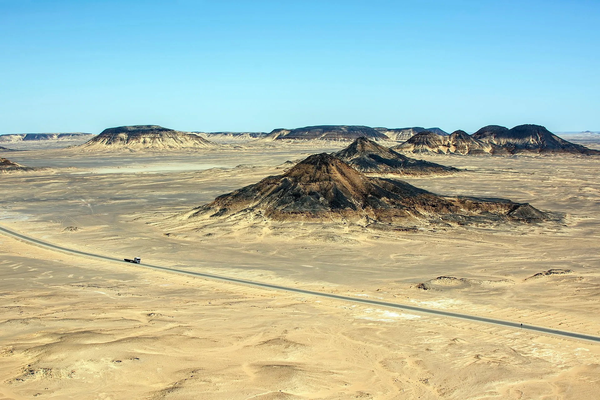 Volcanic black-capped hills rising across the Black Desert near Bahariya Oasis