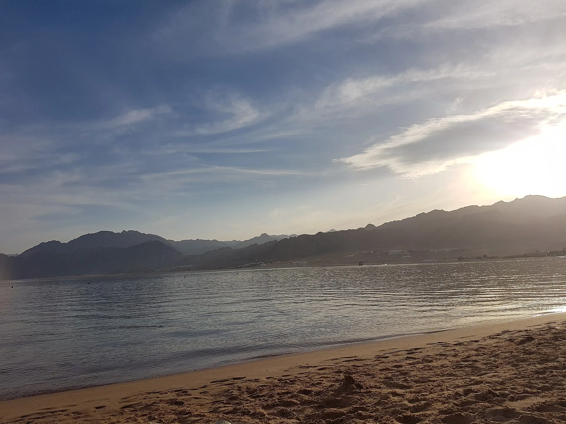 Sun setting over the Gulf of Aqaba coastline and mountains at Dahab