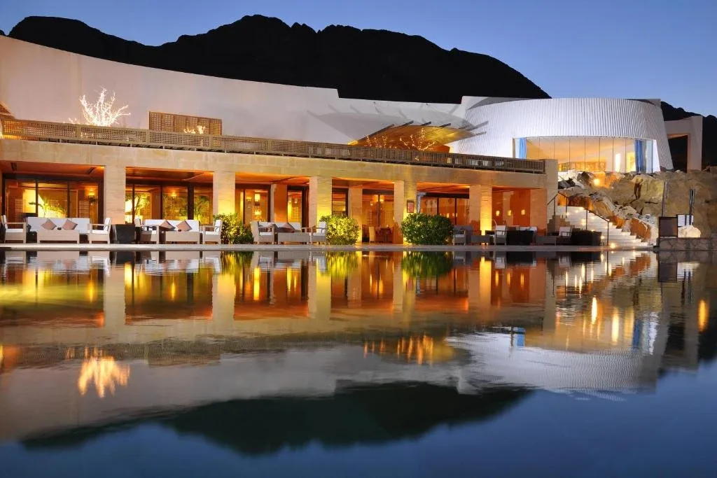 Retac Qunay Dahab Resort lit at dusk beneath the Sinai mountains