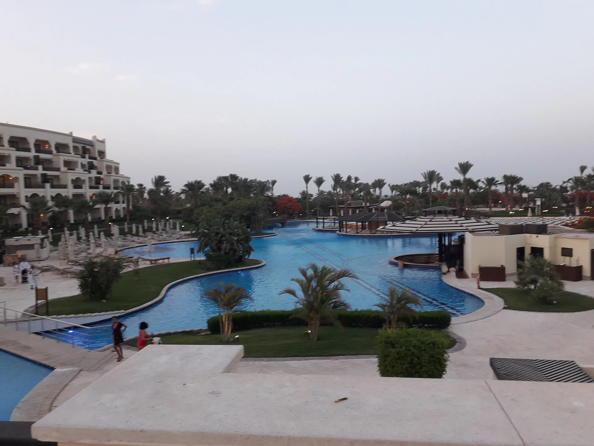 Pool landscape and gardens of Steigenberger ALDAU Beach Hotel at dusk